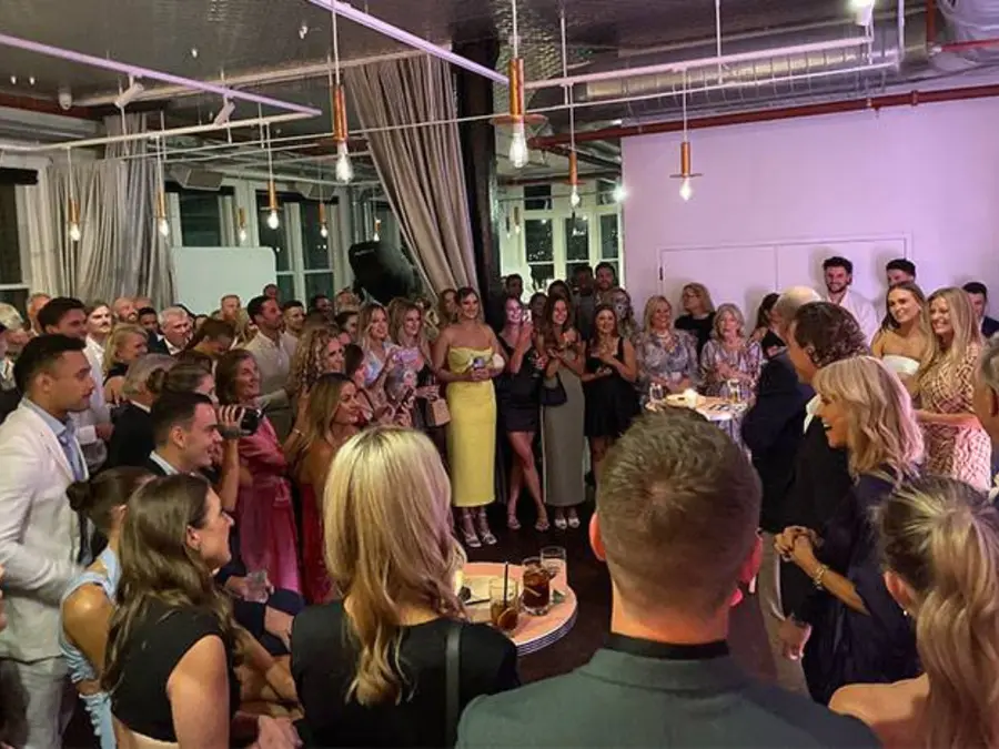 Guests gathered at a lively indoor wedding reception with a Heaven 7 mobile bar