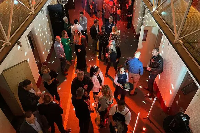 Guests at a crowded corporate party with red lighting