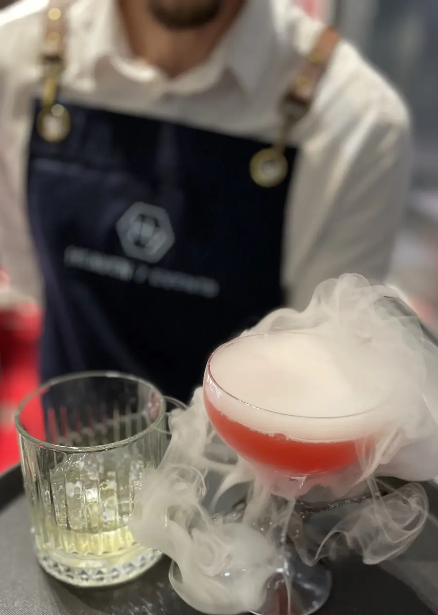 Bartender serving a smoking pink cocktail