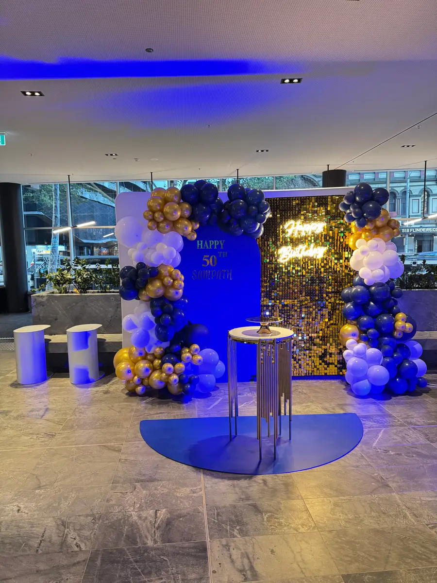 50th birthday balloon backdrop with a gold sequin wall and neon sign