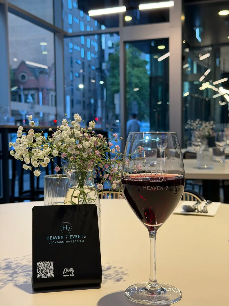 Glass of red wine and flowers on a table at Heaven 7 Cafe