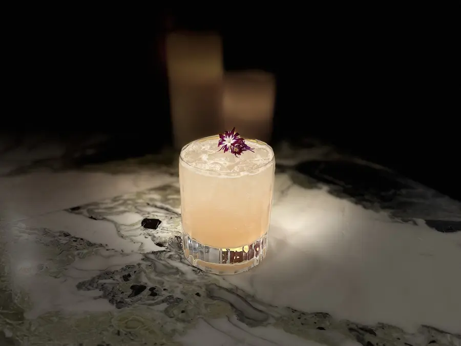Craft cocktail garnished with an edible flower