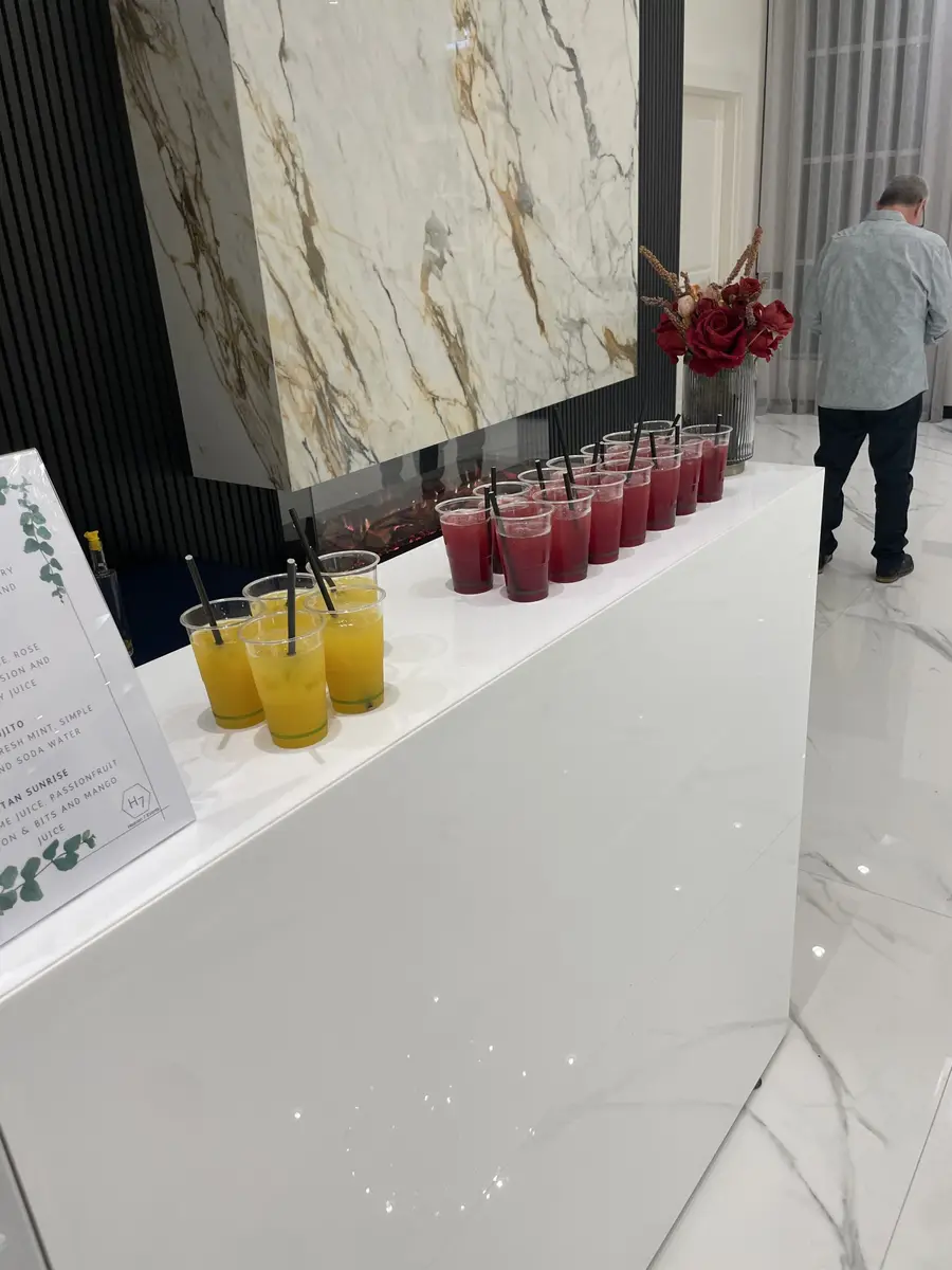 Glasses of fresh juice lined up on a white event bar
