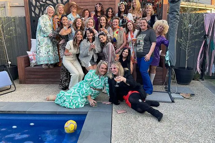 Hens party group posing beside a backyard pool