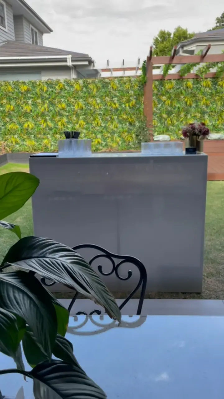 A white mobile bar in front of a green hedge wall at an outdoor Melbourne wedding