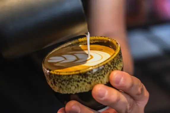 Latte art in a speckled ceramic cup