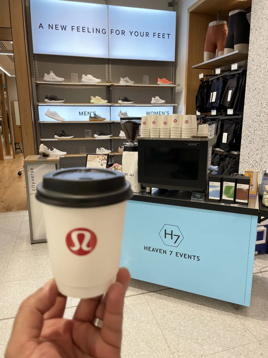 Lululemon-branded coffee cup in front of a Heaven 7 coffee cart