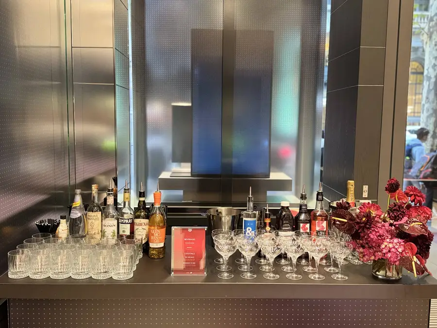 Mobile bar stocked with spirits, glassware and red flowers