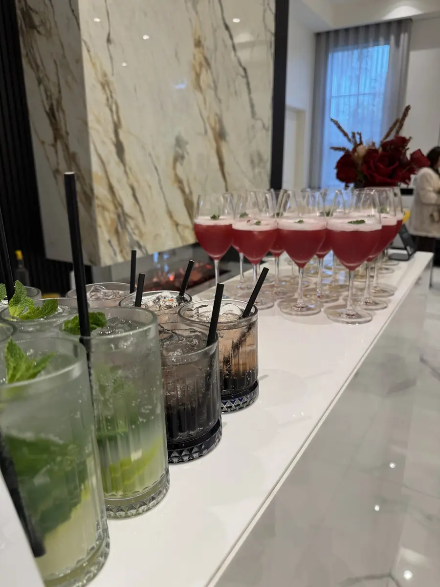 Mojitos and red cocktails lined up on a marble bar