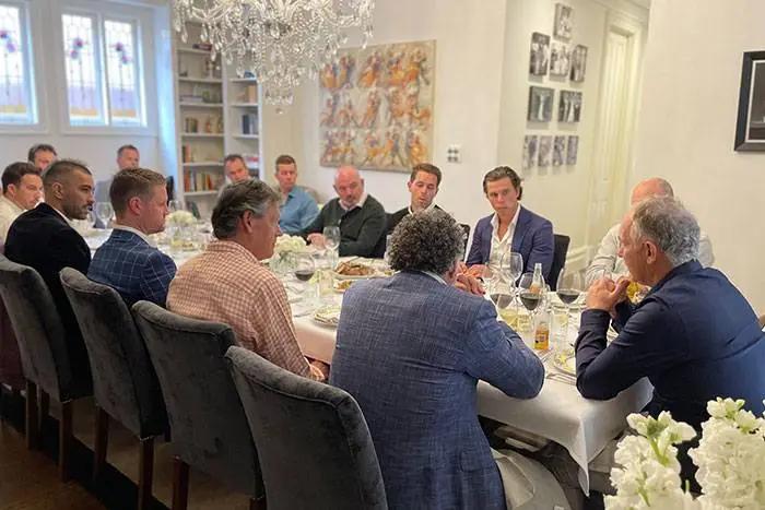 Guests seated at a long dinner table for a business celebration