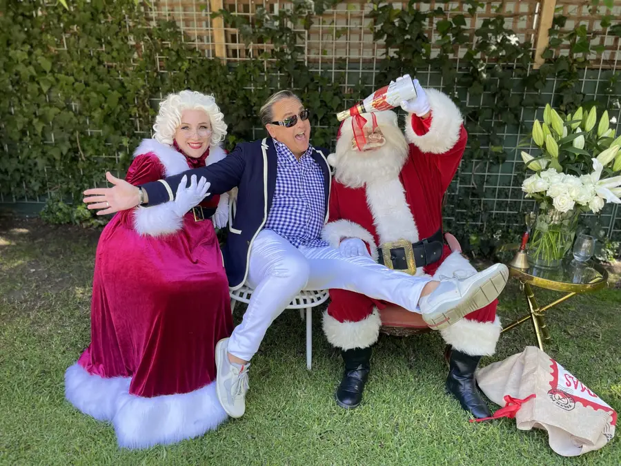 Santa and Mrs Claus with a guest at a Christmas party