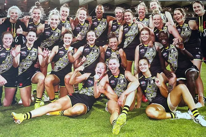 Women’s football team celebrating on the field after a game