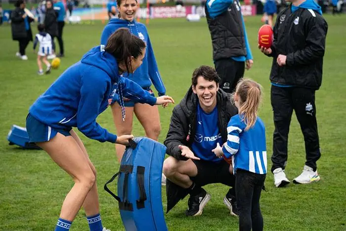Footballers and families on the field at a club family day