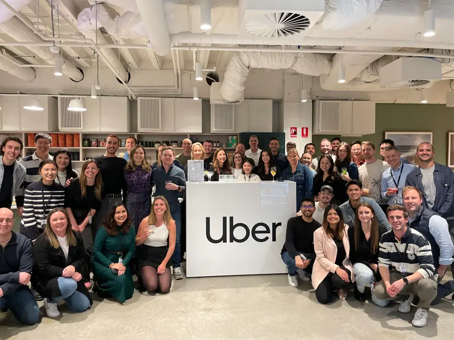 The Uber team gathered around an Uber sign at a corporate event catered by Heaven 7 Events