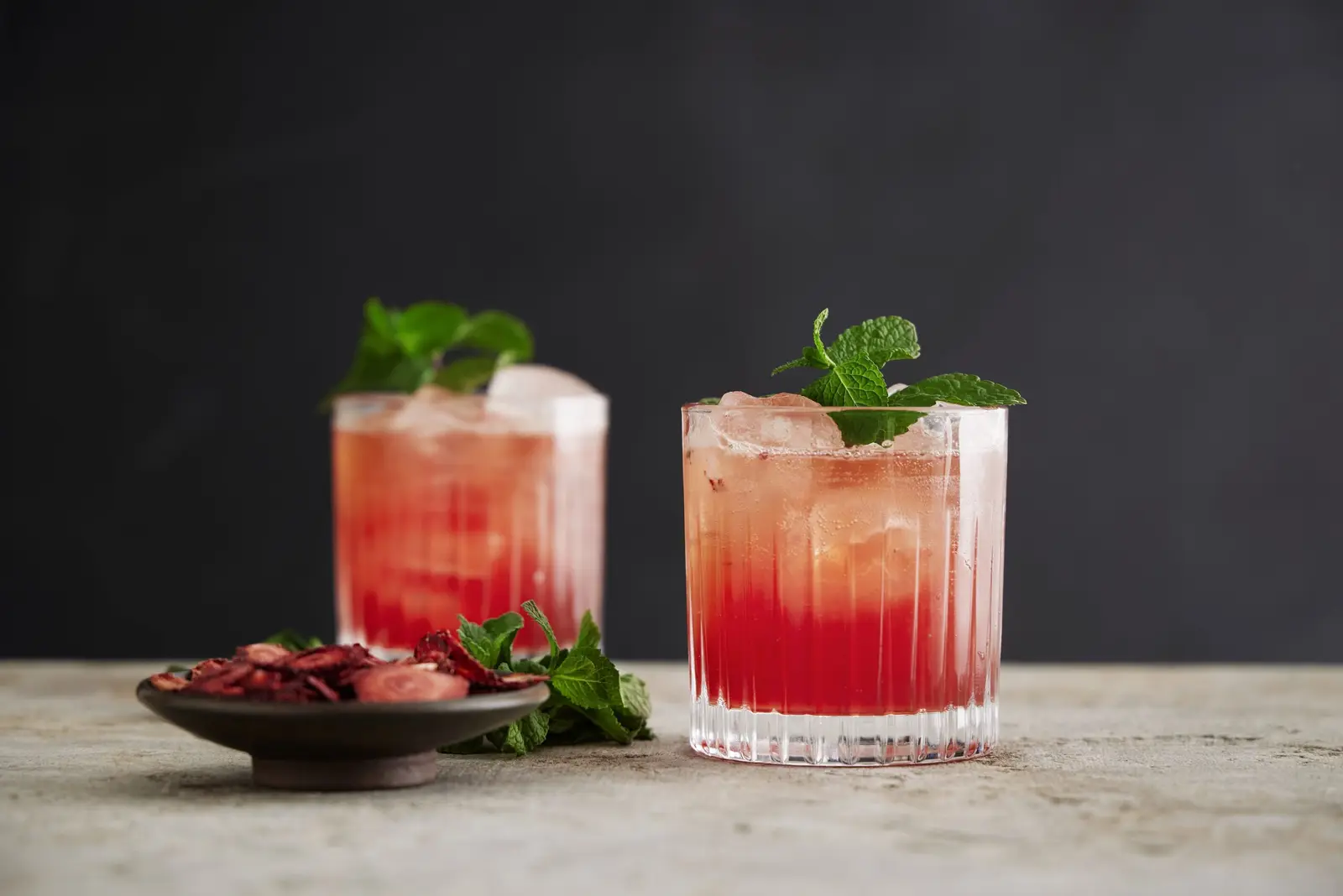 Two red cocktails garnished with fresh mint