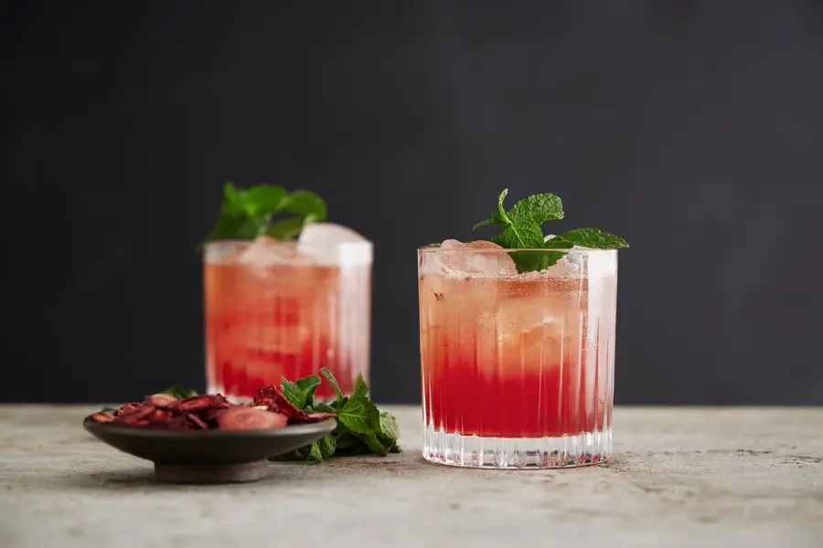 Two red cocktails garnished with fresh mint